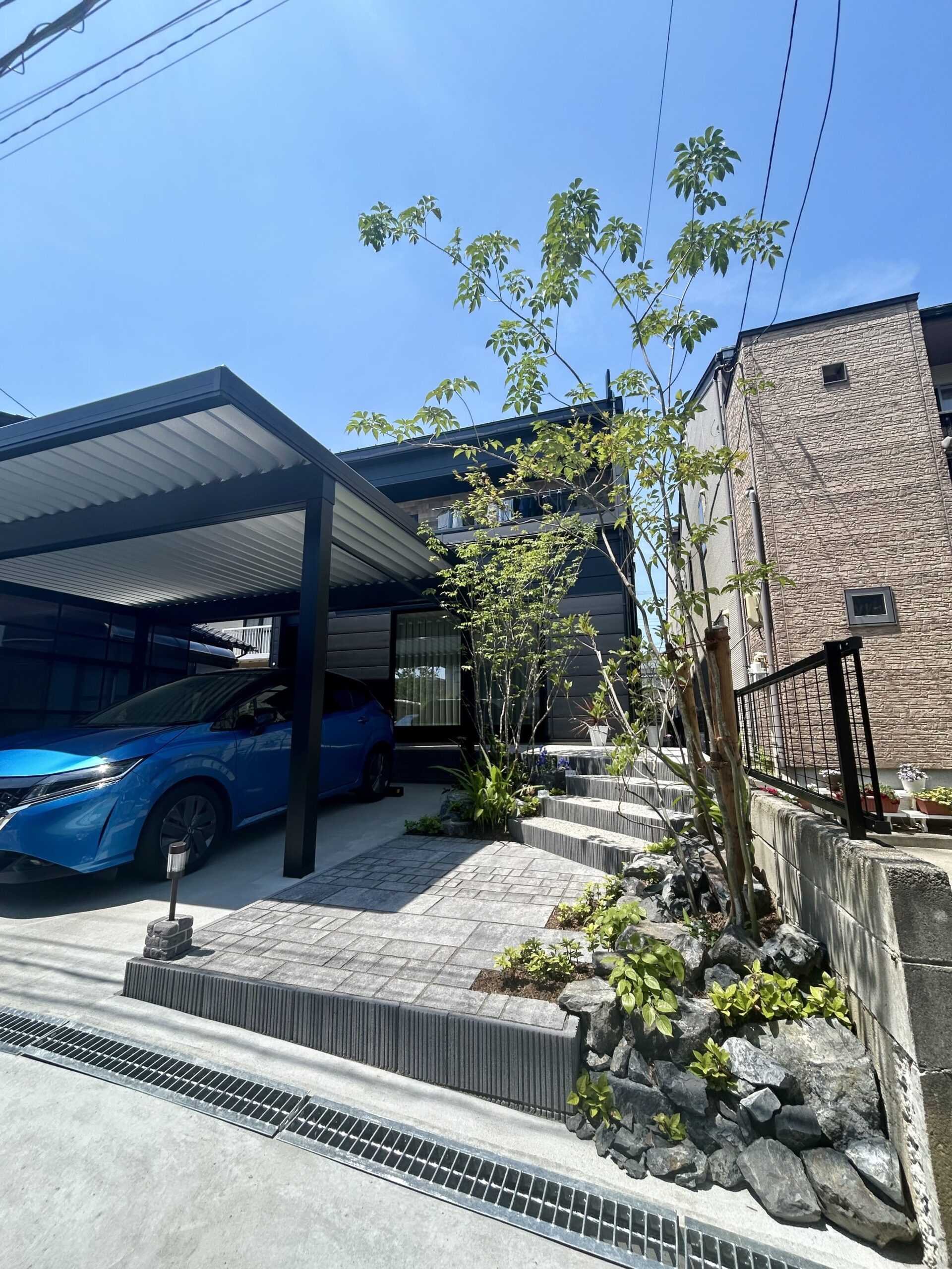 植栽で彩られた、自然石風の舗装材を用いたアプローチ